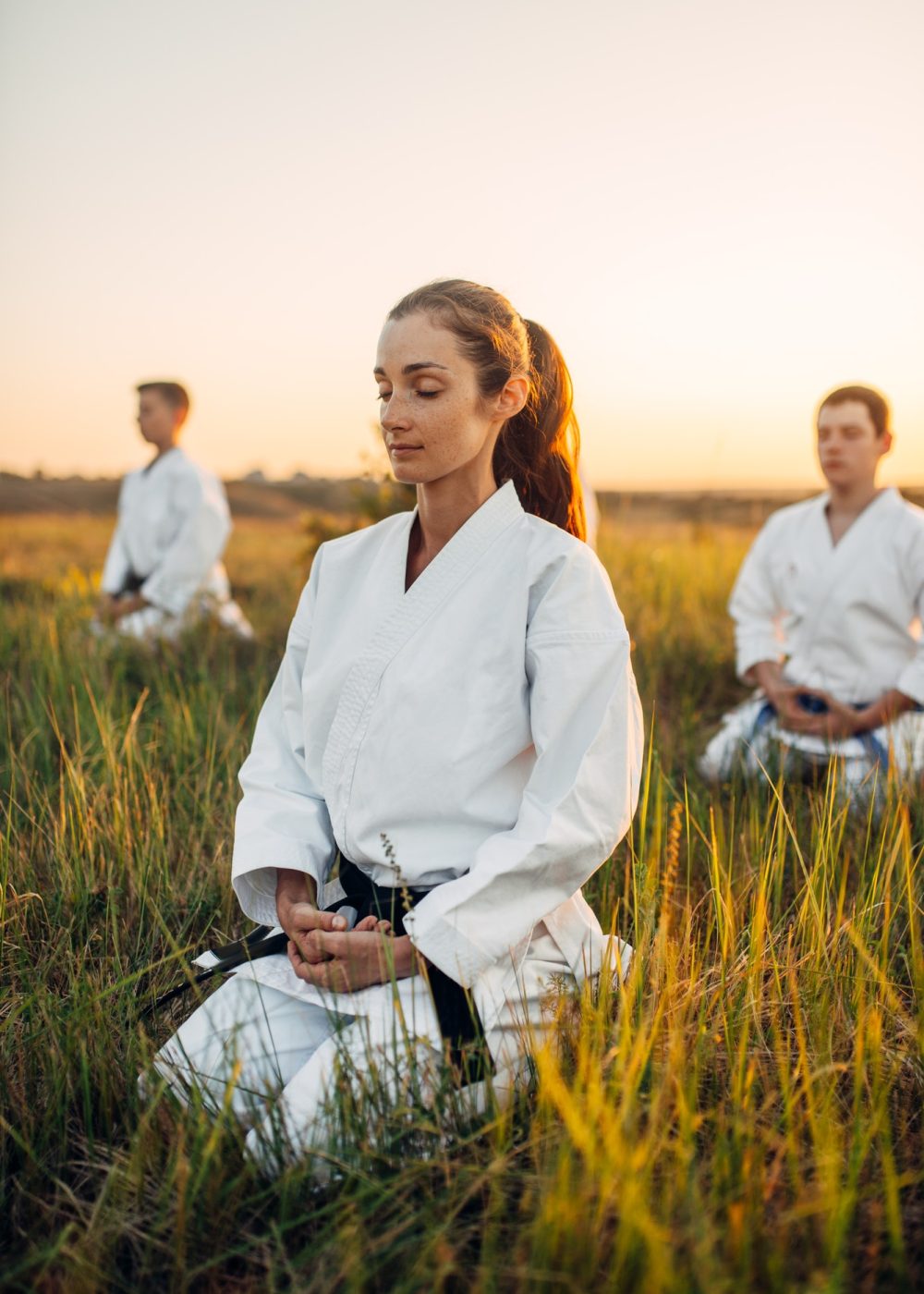 karate-class-meditates-on-training-in-summer-field.jpg karate-class-meditates-on-training-in-summer-field.jpg